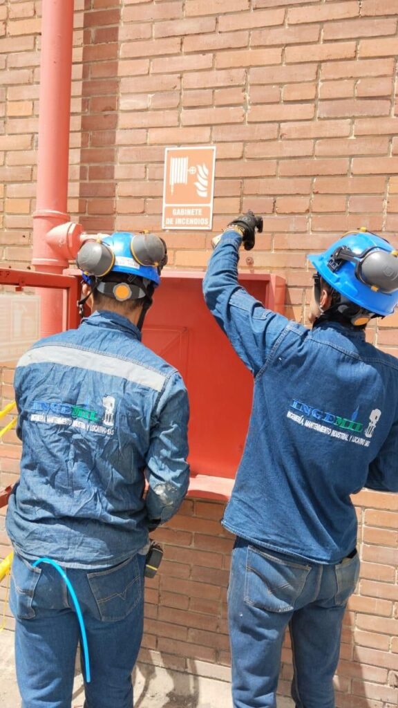 Técnicos de INGEMIL inspeccionando gabinete y señalización contra incendios